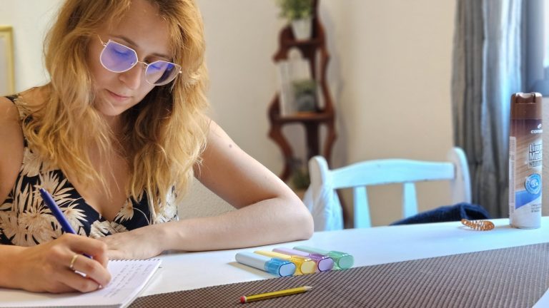 Profesional tomando notas en una mesa con rotuladores de colores